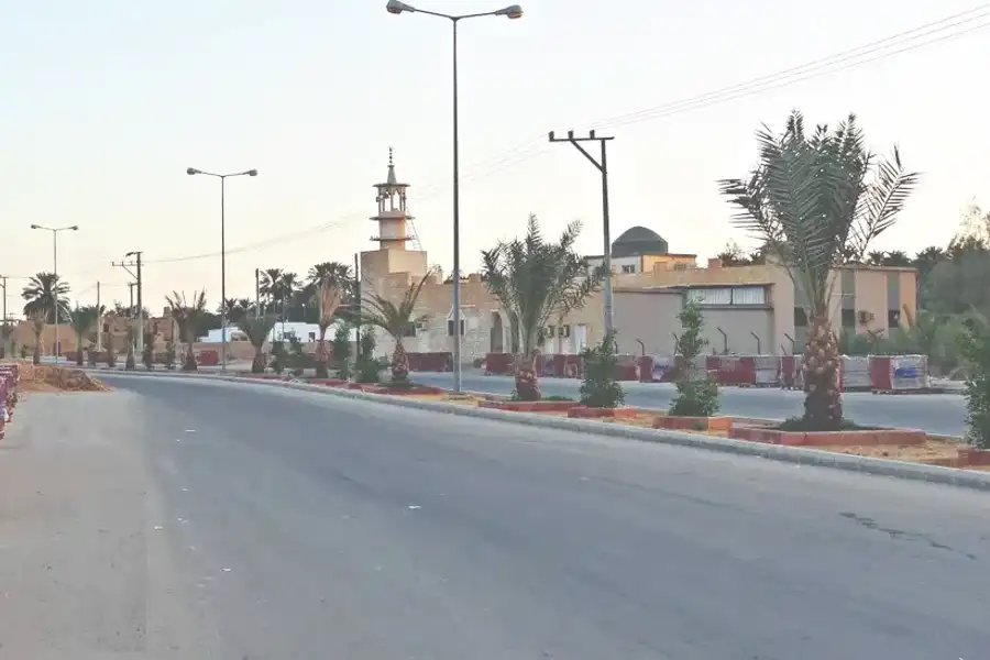 شارع حديث في سدوس تحفه النخيل وتعلوه مئذنة
