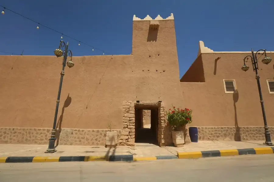 بوابة وبرج مرمّمان بأسلوب العمارة النجدية مع إنارة المساء
