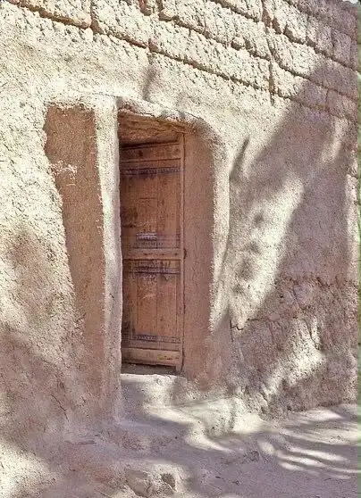 باب خشبي في جدار طيني